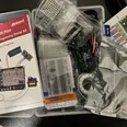 An opened Raspberry Pi Pico starter kit on a desk: a breadboard, bags of sensors and wires, an LED matrix and a pinout card